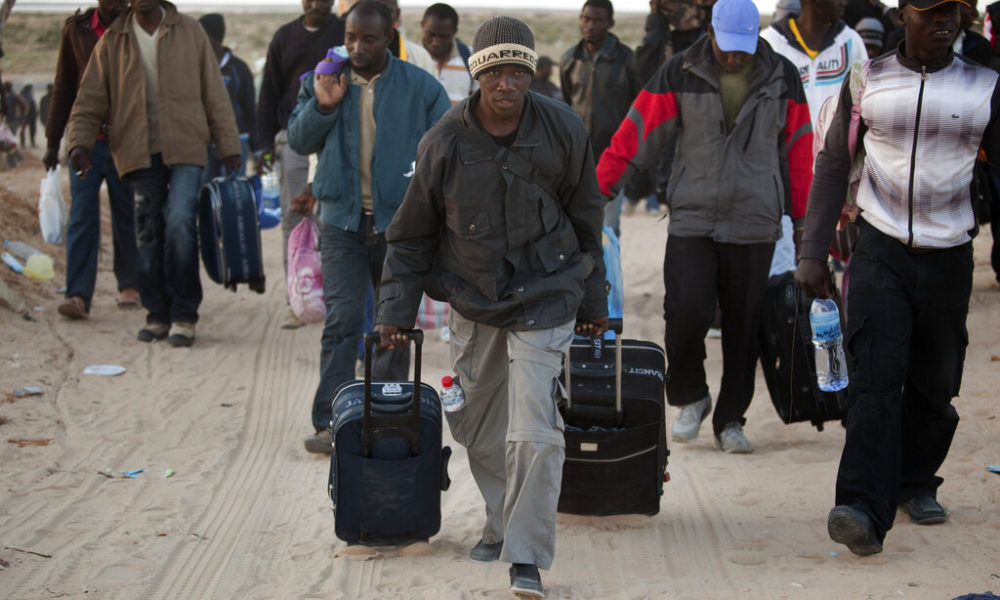 Des hommes du Ghana arrivent dans un camp de réfugiés après avoir traversé la frontière libyenne, près d'un camp de réfugiés mis en place pour les personnes déplacées qui ont récemment traversé la frontière tunisienne, fuyant les troubles en Libye, à Ras Ajdir, en Tunisie, le dimanche 20 mars 2011. Plus de 250 000 travailleurs migrants ont quitté la Libye pour les pays voisins, principalement la Tunisie et l'Égypte, au cours des trois dernières semaines. (AP Photo/Emilio Morenatti)